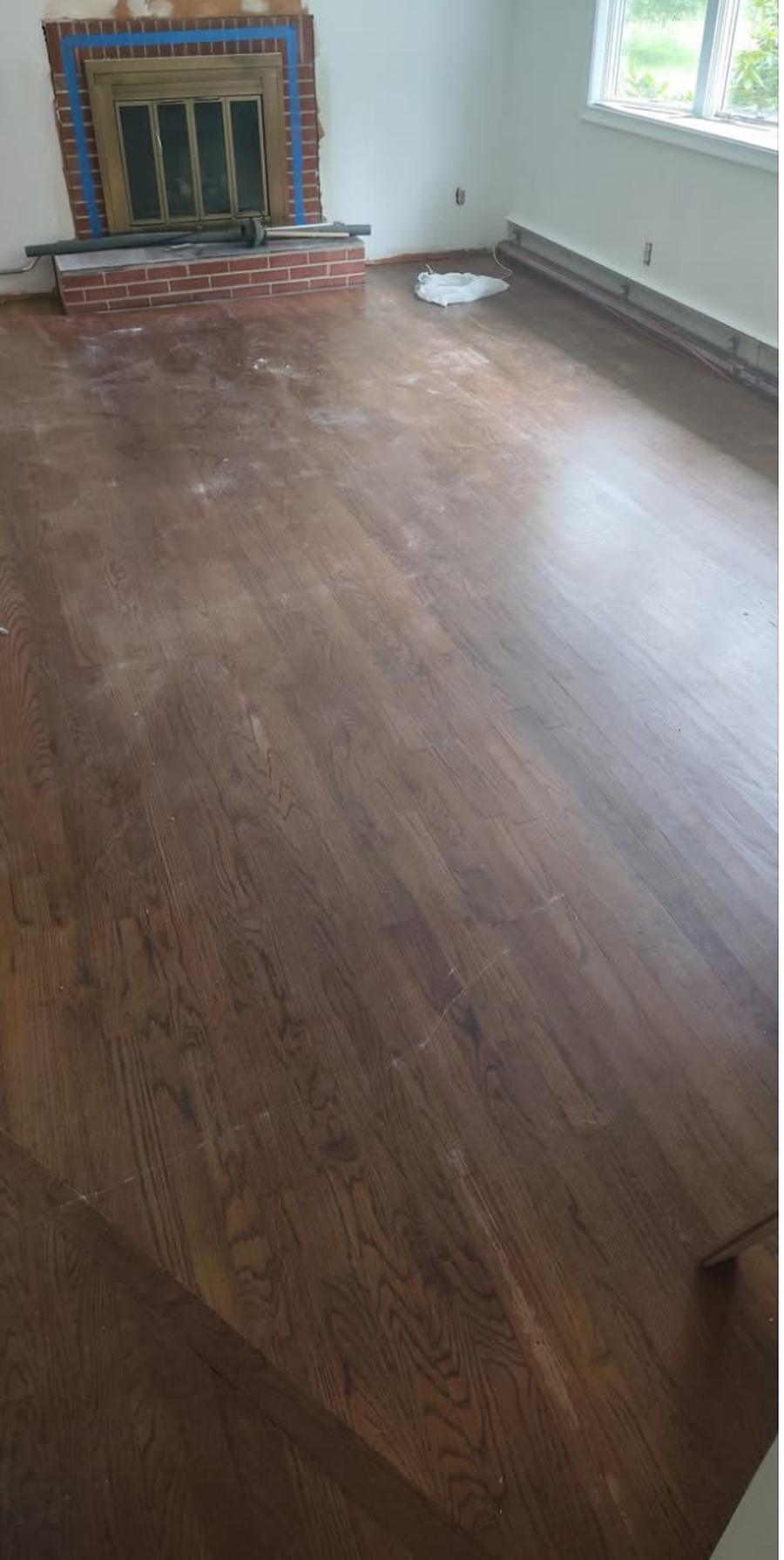 Dark, worn living room floor before refinishing