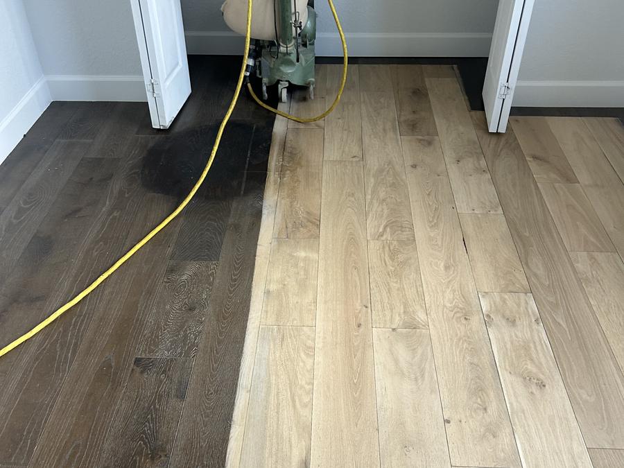 Dark stained floor being sanded back to bare oak