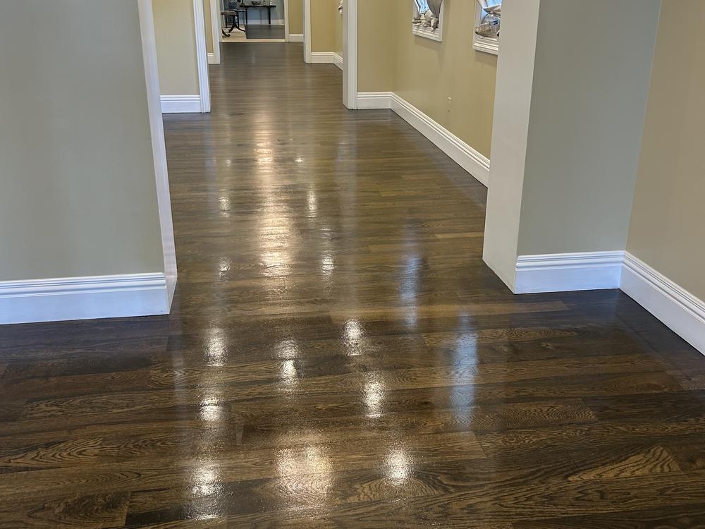 Polished dark oak hallway floor reflecting the lights of a Palm Beach clubhouse